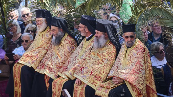 Several priests in golden robes sitting next to each other at an outdoor ceremony, surrounded by spectators, Orthodox ceremony, monks of St John's Monastery, ceremonial foot washing, procession, Maundy Thursday, Megali Pempti, Chora, Patmos, Dodecanese, Greek Islands, Greece