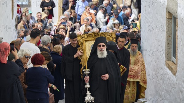 A priest leads a procession through a narrow street, followed by worshippers and surrounded by a crowd, Orthodox ceremony, monks of St John's Monastery, ceremonial washing of feet, procession, Maundy Thursday, Megali Pempti, Chora, Patmos, Dodecanese, Greek Islands, Greece