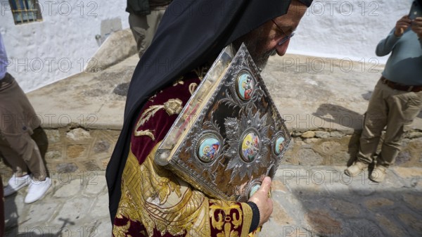 A priest carries an ornate book during a procession, dressed in richly decorated fabrics, Orthodox ceremony, monks of St John's Monastery, ceremonial washing of feet, procession, Maundy Thursday, Megali Pempti, Chora, Patmos, Dodecanese, Greek Islands, Greece