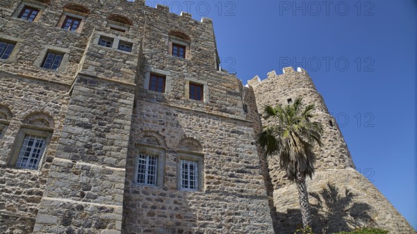 Detailed view of a castle with stone walls and windows, palm trees next to it, Monastery of St John the Theologian, Monastery of St John the Theologian, Southern Wall, World Heritage Site 1999, Chora, Patmos, Dodecanese, Greek Islands, Greece