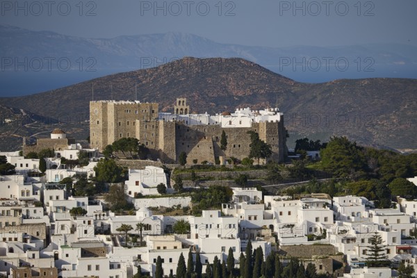 View of a castle above white houses, framed by mountains and the sea, Monastery of St John the Theologian, Monastery of St John the Theologian, World Heritage Site 1999, Chora, Patmos, Dodecanese, Greek Islands, Greece