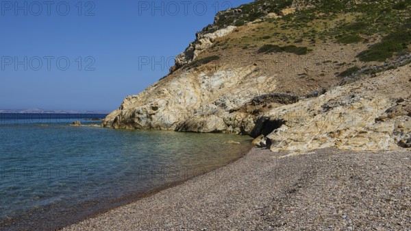 Stone beach under clear blue sky with coastline and water, Lambi Beach, Lambi Bay, Patmos, Dodecanese, Greek Islands, Greece