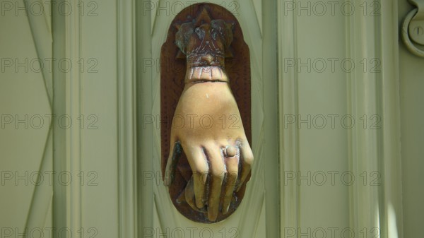 Detail of an ancient, hand-shaped door knocker on a green door, Chora, UNESCO World Heritage Site 1999, Patmos, Dodecanese, Greek Islands, Greece