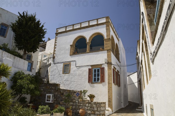 White house with striking balcony and brick details under a clear blue sky, Lion's Alley, Captain's House, Chora, UNESCO World Heritage Site 1999, Patmos, Dodecanese, Greek Islands, Greece