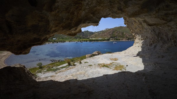 View from a cave onto a blue sea with rocks and coastal landscape in the sunlight, Petra beach, cave, rocks of Kalikatsou, Patmos, Dodecanese, Greek Islands, Greece