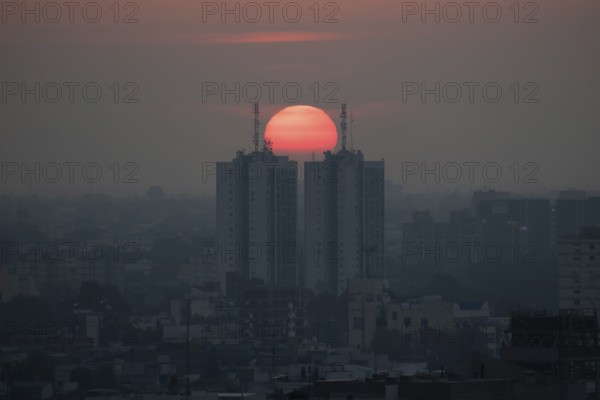 Sunset over skyscrapers in Buenos Aires, symmetry in photography, symbolic image for heat, global warming, climate change, environmental problems, smog, Buenos Aires, Argentina