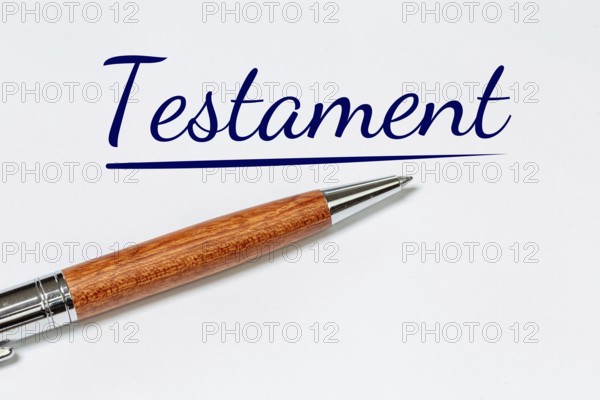 Symbolic image of a will: biros on a white sheet with added text TESTAMENT