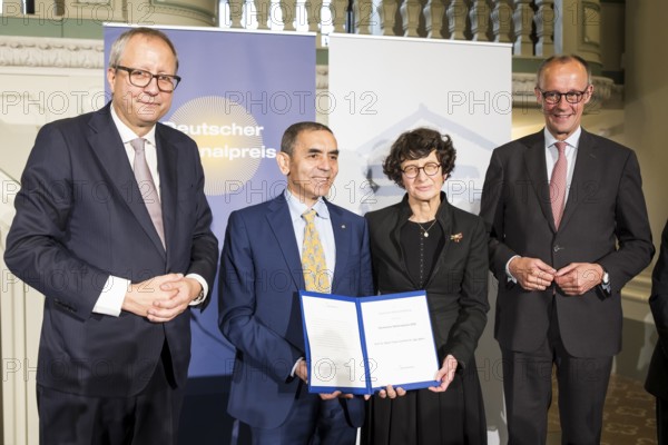 Thomas Mirow (Chairman of the Board of the German National Foundation), Ugur Sahin and Özlem Türeci (founders of Biontech SE) and Friedrich Merz (Chancellor of the Federal Republic of Germany) at the award ceremony for the German National Prize 2025 in the Französische Friedrichstadtkirche, Berlin, on 10 June 2025
