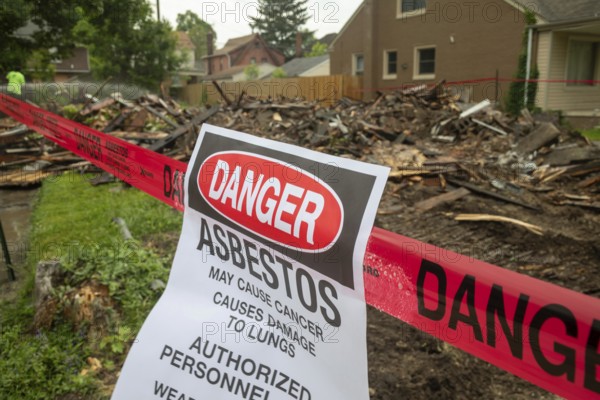 Detroit, Michigan - Signs warn of asbestos danger where a house was demolished. The house had been heavily damaged by fire a year earlier and was a neighborhood eyesore