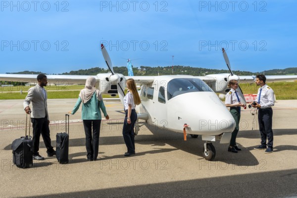 Pilots and passengers engaging in preparations for an upcoming flight on a small airplane at a sunny airport, surrounded by blue skies