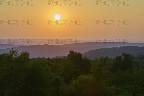 Sunset over wooded hills with orange-coloured sky, peaceful evening mood, Geishöhe, Dammbach, Spessart, Bavaria, Germany
