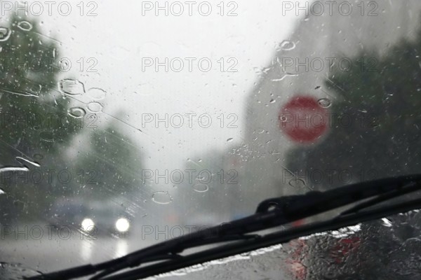 Driving a car in rainy weather, view through the windscreen, Germany