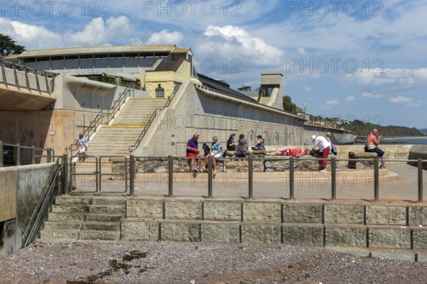 People enjoying sunny weather on seafront at Dawlish, south Devon, England, UK