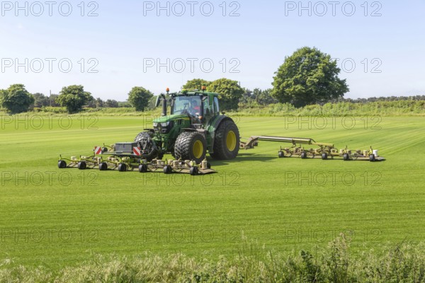 John Deere tractor mowing grass turf field, Butley, Suffolk, England, UK