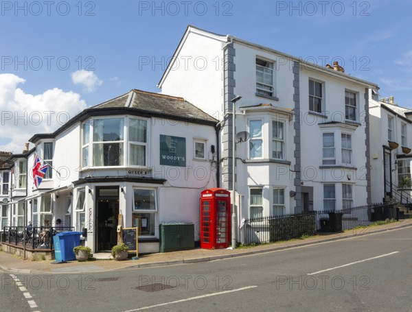 Historic buildings old red telephone box, Woody's cafe, Queen Street, Dawlish, south Devon, England, UK