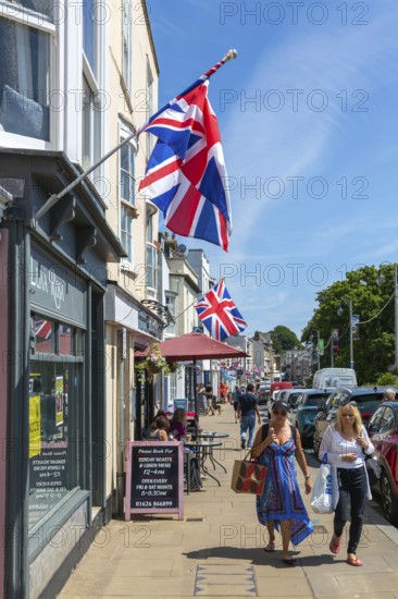 Union Jack flags on shops in street of historic buildings, The Strand, Dawlish, south Devon, England, UK