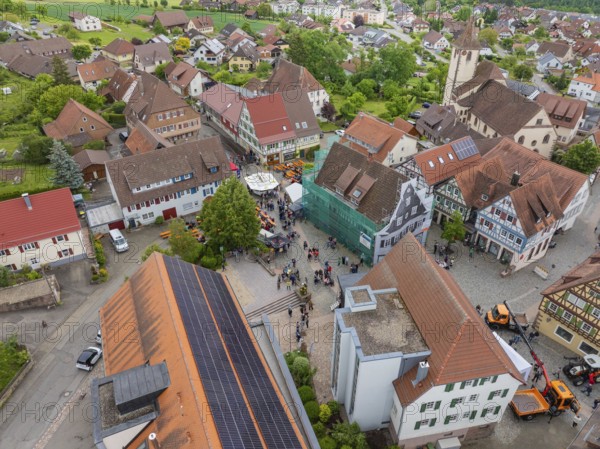 Aerial view of a small village with traditional buildings and a central church with surrounding green areas, family festival in Neubulach, district of Calw, Germany