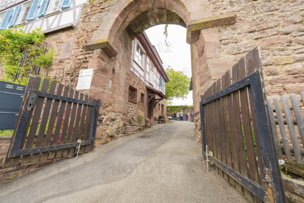 Entrance gate to an alley with traditional stone walls, historical ambience, family festival in Neubulach, Calw district, Germany
