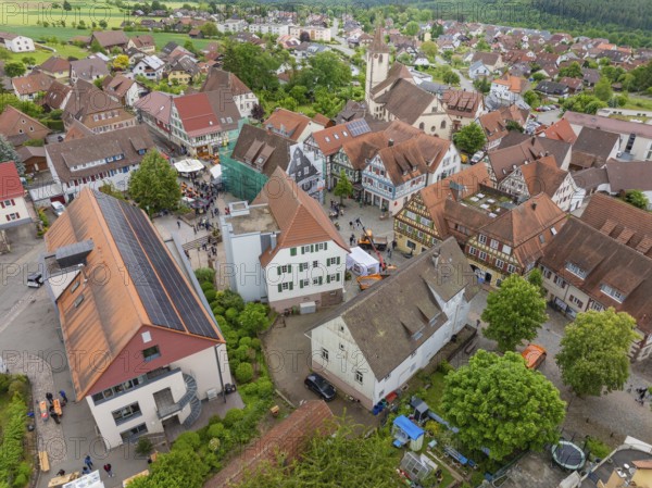 Aerial view of a village with historic architecture, numerous red roofs and a central church, family festival in Neubulach, district of Calw, Germany