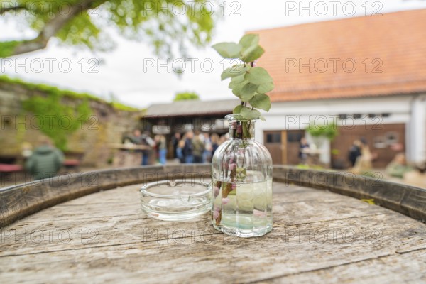 Wooden table with decorative glass bottle in a relaxed outdoor area at an event, family celebration in Neubulach, district of Calw, Germany