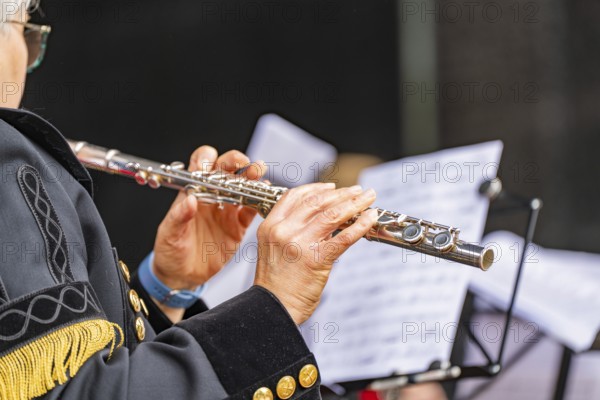 Musician playing the flute during a performance, in uniform with sheet music, family party in Neubulach, district of Calw, Germany