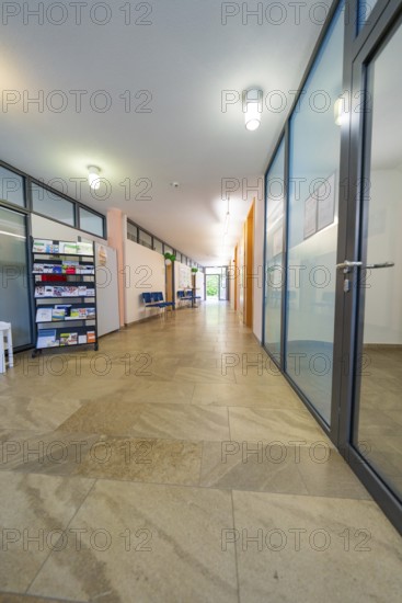 Long, modern hallway with glass doors, brochure rack and bright light, family party in Neubulach, Calw district, Germany