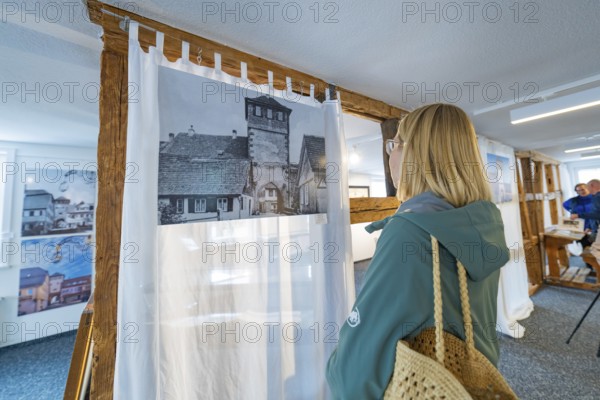 Woman looking at historical photography in a modern designed room, family celebration in Neubulach, district of Calw, Germany
