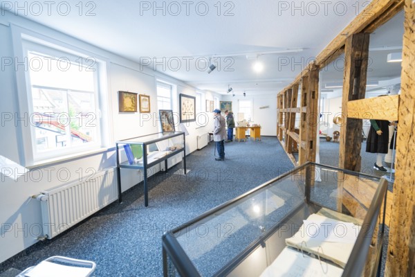 White modern exhibition space with works of art and few visitors, family party in Neubulach, district of Calw, Germany