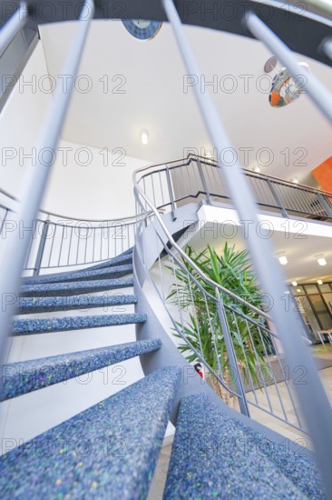 Modern spiral staircase with blue steps and a stylish banister in a bright interior, town hall, family celebration in Neubulach, district of Calw, Germany