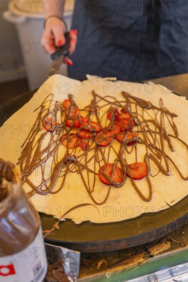 Crêpe with chocolate and strawberries being prepared on a hotplate, Calw railway station festival, Black Forest, Germany