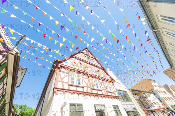 Colourfully decorated town with half-timbered houses and colourful flags in summer, Calw station festival, Black Forest, Germany