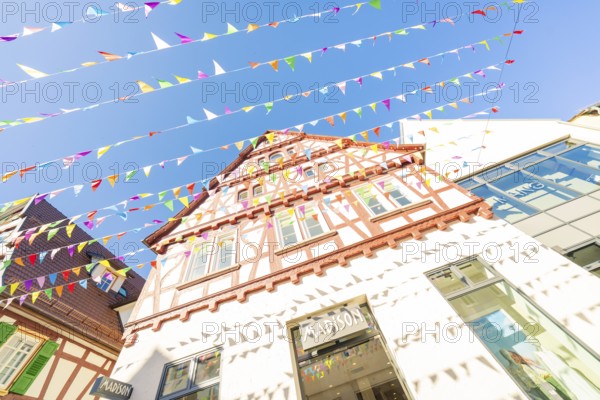 Colourfully decorated old town with blue sky and pennants, Calw station festival, Black Forest, Germany