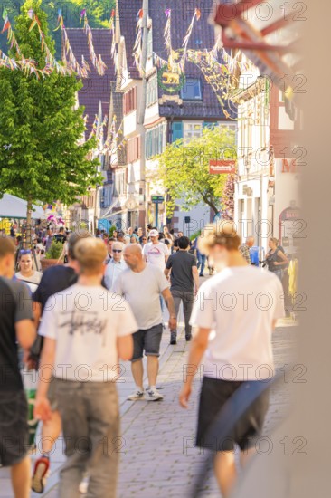 Lively city street full of people on a sunny day, Calw railway station festival, Black Forest, Germany