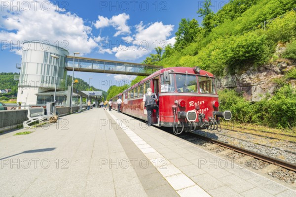 Red train stands on the platform in bright daylight, Calw railway station festival, Black Forest, Germany