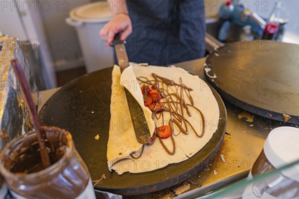 Crepes with Nutella and strawberries on a hot pan, Calw railway station festival, Black Forest, Germany