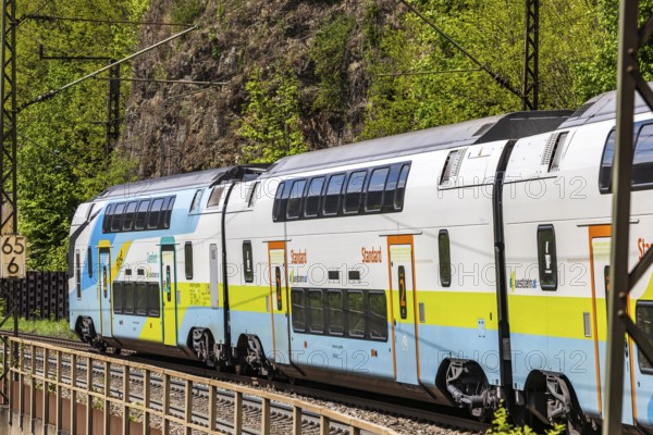 Train of the Austrian Westbahn en route on the winding railway line of the Geislinger Steige. Landscape on the railway's Filstalline line in spring. Amstetten, Baden-Württemberg, Germany