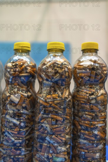 Plastic bottles are filled with discarded cigarette butts, highlighting the pervasive issue of environmental pollution and the need for responsible waste disposal