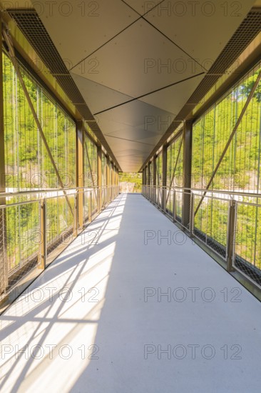 A modern glass and metal bridge with a shadow pattern in sunny weather, Zob extension with bridge construction for the new Herman Hesse railway, Calw, Black Forest, Germany