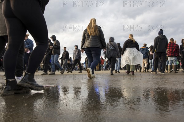 Festival visitors are reflected in a puddle at the Rock am Ring Festival on Sunday, Nürburgring race track race track, 08.06.2025