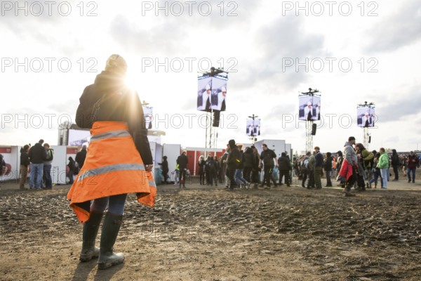 A festival visitor stands in front of a muddy area in the evening sun at the Rock am Ring Festival on Sunday, Nürburgring race track race track, 08.06.2025