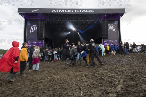 Festival visitors dance in the mud in front of the Atmos Stage at the Rock am Ring Festival on Sunday, Nürburgring race track race track, 08.06.2025