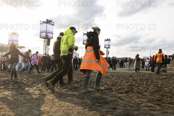 Festival visitors walk through mud in the evening sun at the Rock am Ring Festival on Sunday, Nürburgring race track race track, 08.06.2025