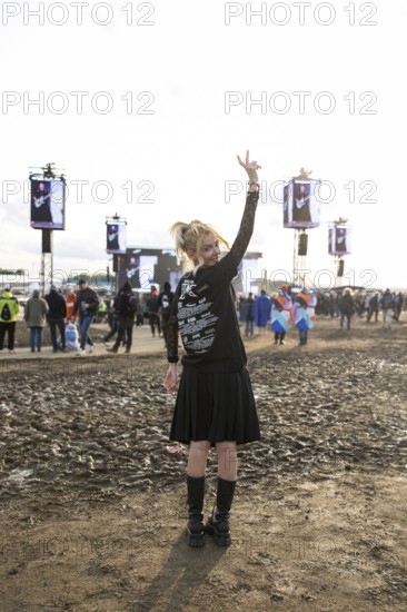 A festival visitor from Turkey poses in front of a muddy area in the evening sun at the Rock am Ring Festival on Sunday, Nürburgring race track race track, 08.06.2025