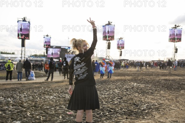 A festival visitor from Turkey poses in front of a muddy area in the evening sun at the Rock am Ring Festival on Sunday, Nürburgring race track race track, 08.06.2025