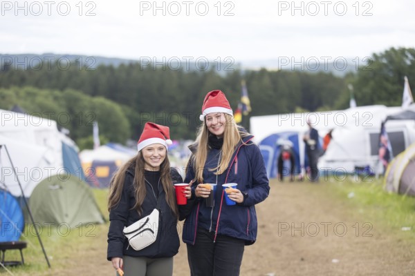 Joline and Lisa with Christmas hats on a campsite at the Rock am Ring Festival on Saturday, Nürburgring race track race track, 07.06.2025