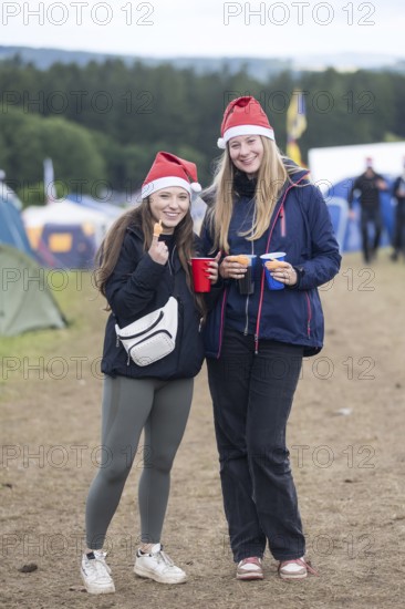 Joline and Lisa with Christmas hats on a campsite at the Rock am Ring Festival on Saturday, Nürburgring race track race track, 07.06.2025