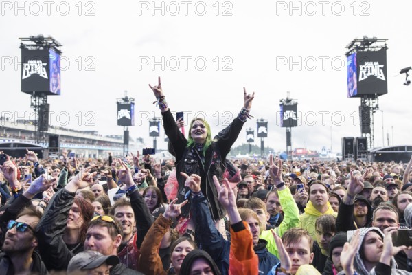 Festival visitor on shoulders with a French fries fork shaped like a hand at the Rock am Ring Festival on Friday, Nürburgring race track race track, 07.06.2025