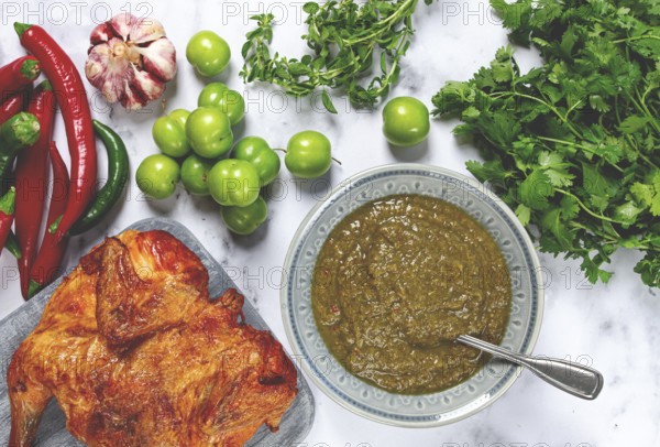 Tkemali sauce, made from green cherry plum, with ingredients on the table, tobacco chicken, top view, Georgian cuisine, no people
