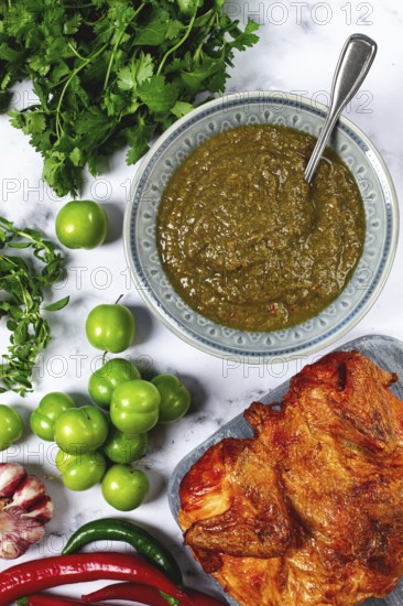 Tkemali sauce, made from green cherry plum, with ingredients on the table, tobacco chicken, top view, Georgian cuisine, no people