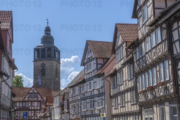 Kirchstrasse with a view of St. Crucis Church, Bad Sooden, Allendorf, Allendorf district, historic old town with numerous half-timbered houses under monument protection, gabled houses, staggered storeys, tower clock, flag, Werra, blue sky, clouds, Meissner district, Hesse, Germany